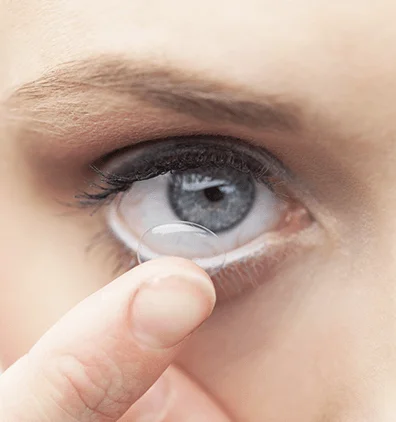 Female is putting a contact lens into her eye